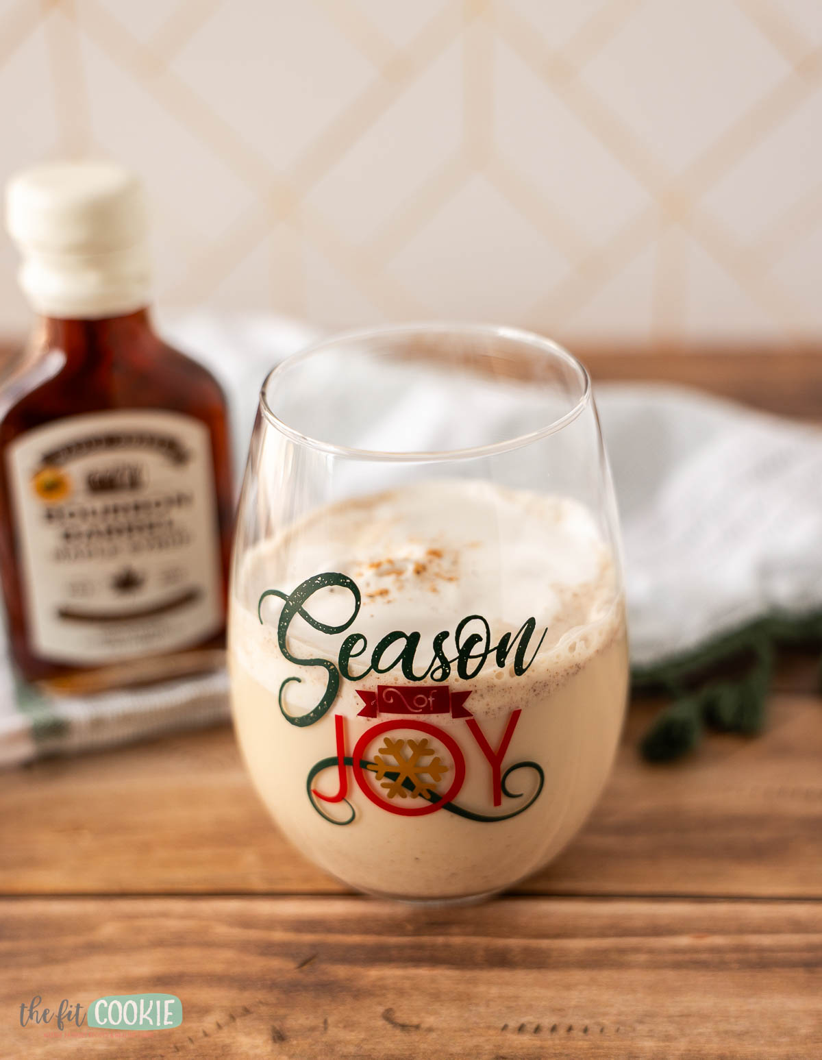A glass of creamy dairy free eggnog with dairy free whipped cream on top.