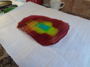 A piece of wax paper with a red, green, and blue dye on it.