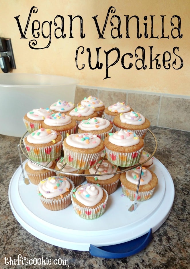 tray of vegan vanilla cupcakes topped with pink frosting and cute sprinkles