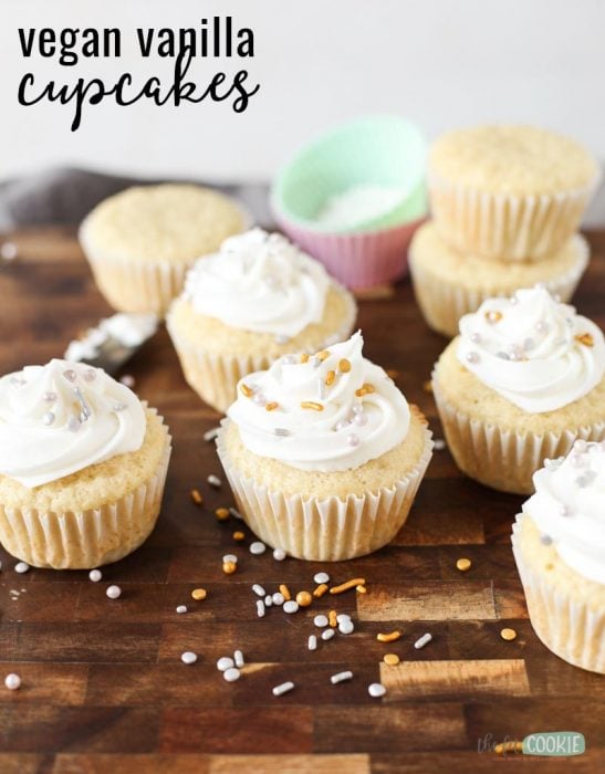 vegan nut free vanilla cupcakes with white frosting on a wood cutting board