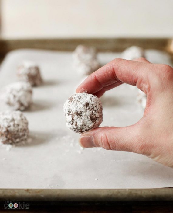 hand holding a gluten free vegan no bake cookie covered in powdered sugar