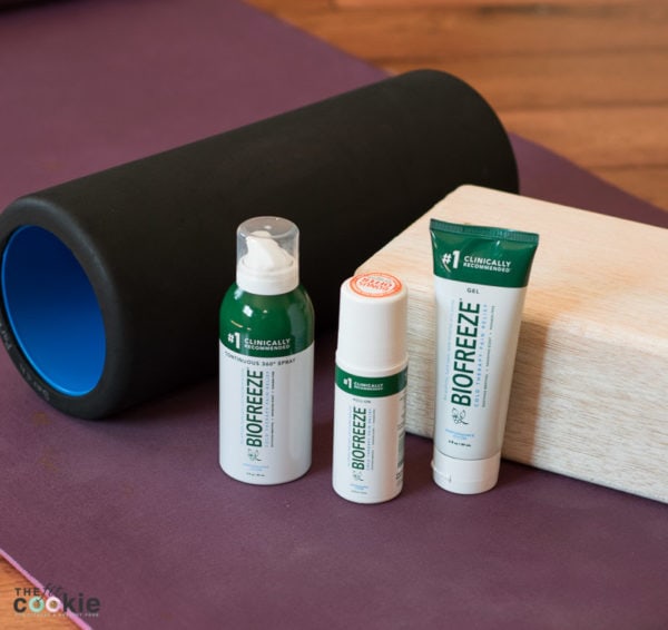 bottle of Biofreeze next to foam roller and yoga block for workout recovery
