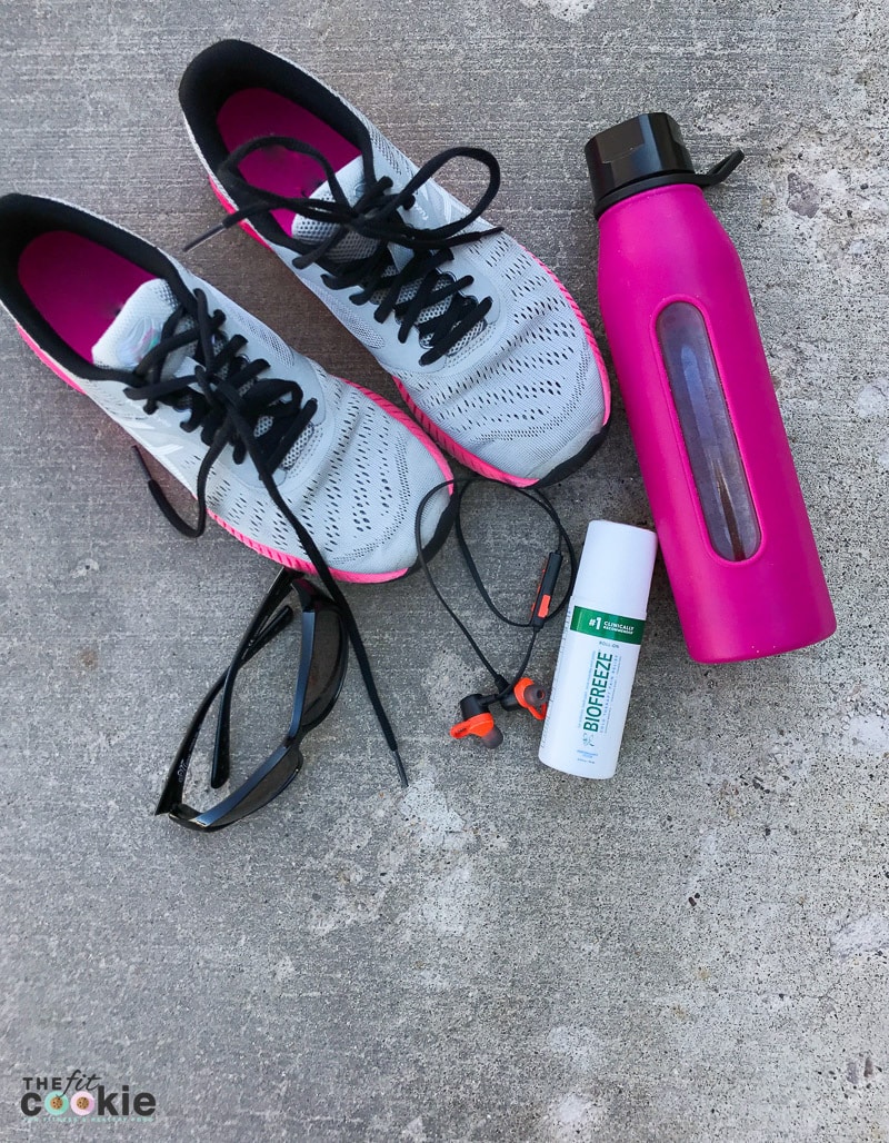 fitness gear (shoes, water bottle) next to bottle of biofreeze for workout recovery