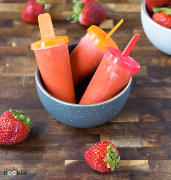 If you're looking for some healthy cool treats for summer, make these Strawberry Mango Popsicles - they only have 3 ingredients! Plus they are paleo and vegan, too - TheFitCookie.com