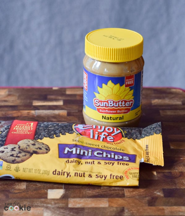 If you're struggling with soy allergies or food allergies in general, finding great alternatives for traditional ingredients can be tough, but it can be done! Here are our favorite soy free cooking products that we use in our kitchen - @TheFitCookie | jar of SunButter and bag of chocolate chips on a wood cutting board |