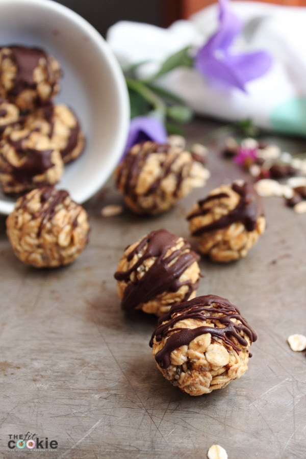 several energy balls made with oats on a cookie sheet with chocolate on top. 