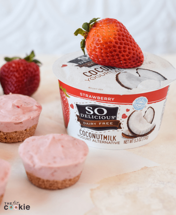 vegan mini strawberry cheesecakes next to container of So Delicious strawberry coconutmilk yogurt