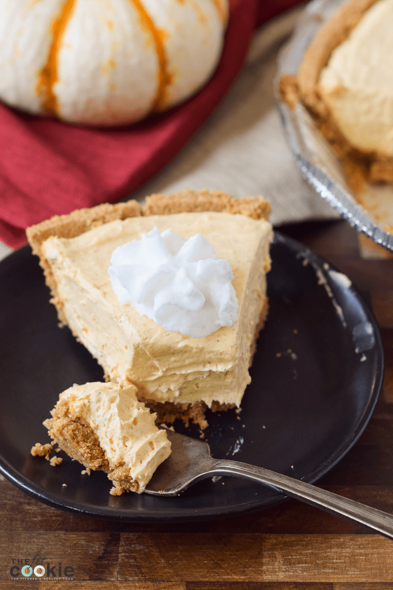 slice of vegan pumpkin cheesecake topped with dairy free whipped cream