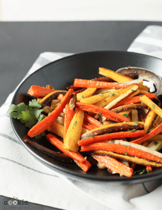 garlic roasted rainbow carrots in a black dish