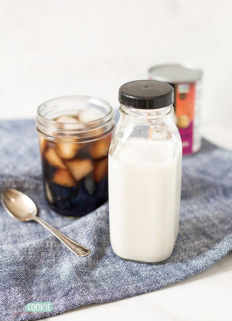 glass bottle of paleo coffee creamer next to a glass of coffee.