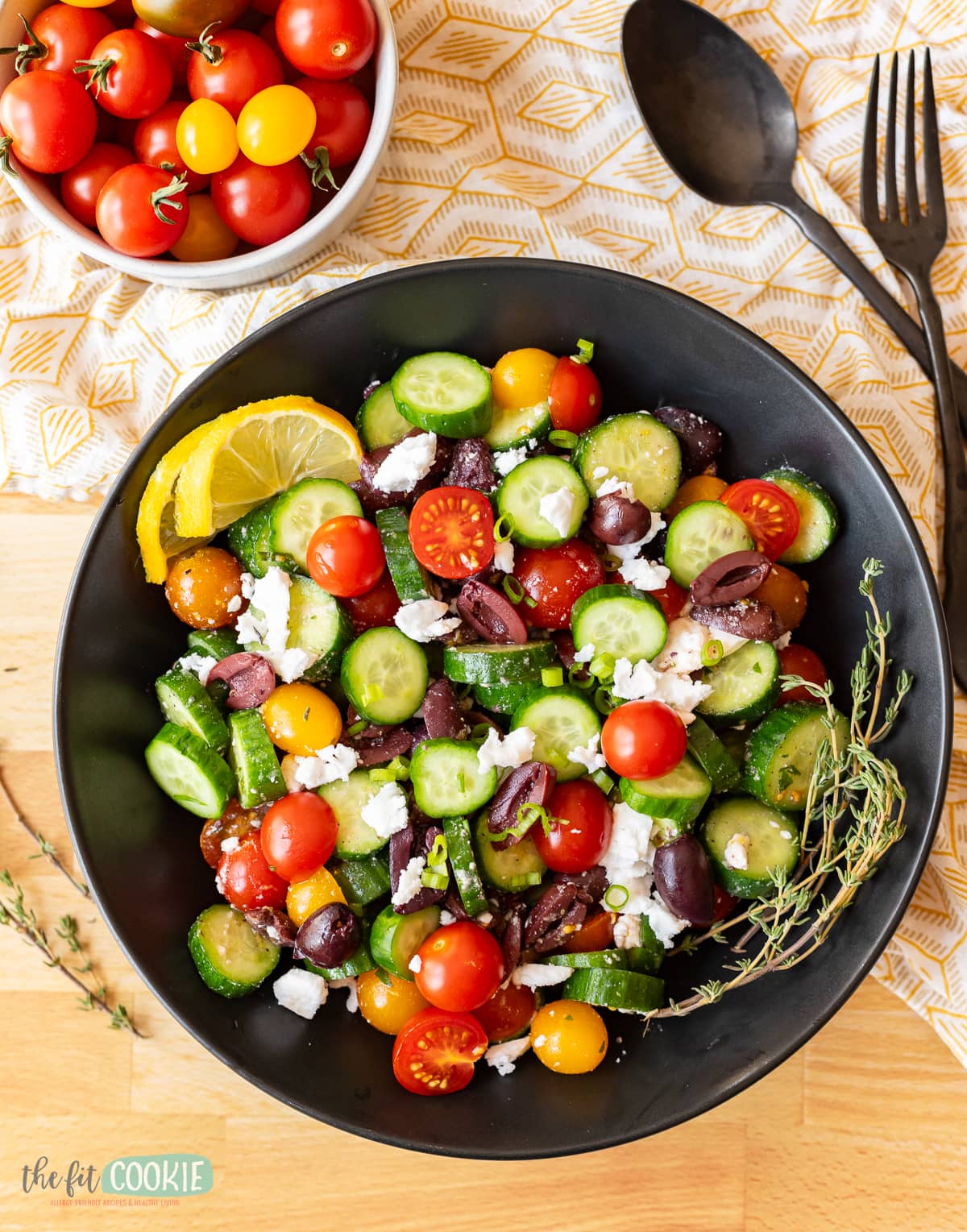 Greek salad with cucumbers, tomatoes and feta cheese served in a black bowl.