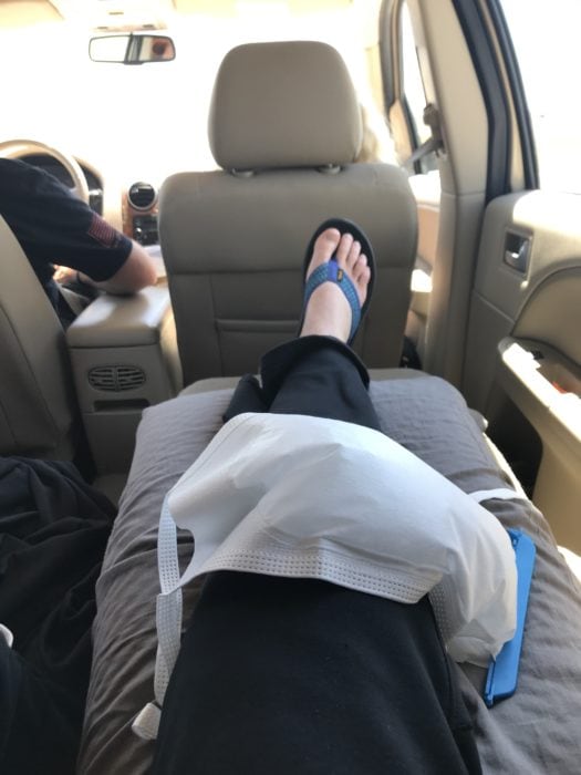 photo of leg propped up after IT band knee surgery with an ice pack