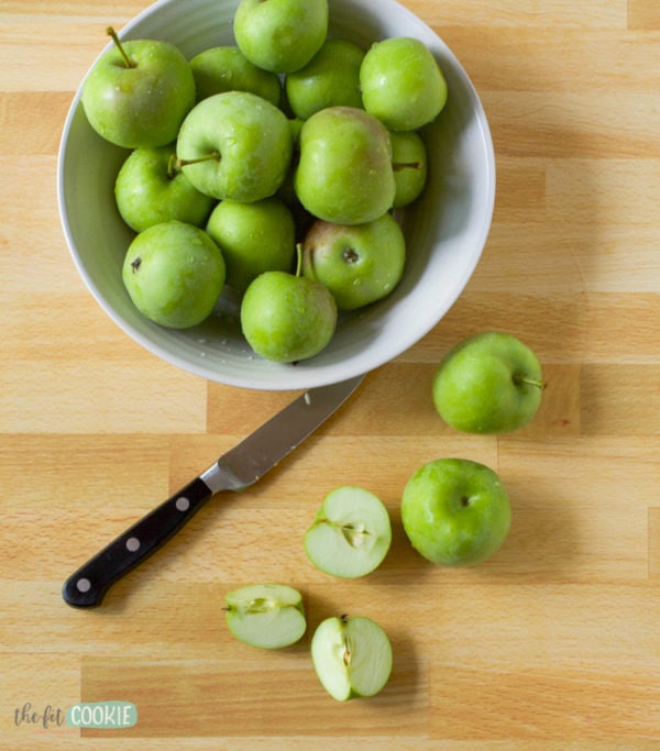 overhead photo of green apples on a cutting board