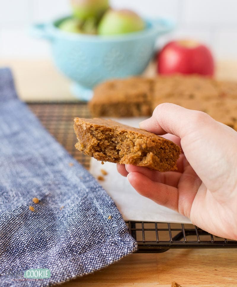 hand holding an apple blondie with a bite taken