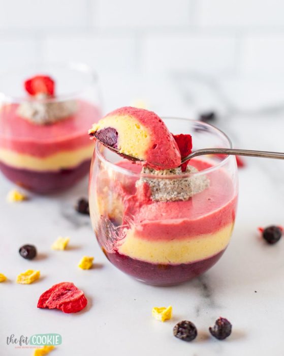 glass of colorful fruit mousse with a spoon