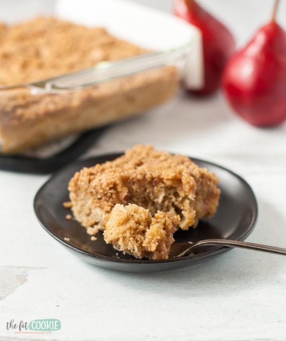 gluten free pear coffee cake on a black plate with a bite on a fork