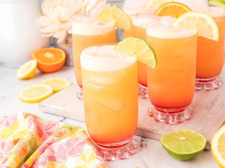 A tray of refreshing mocktail recipes garnished with orange slices and limes.