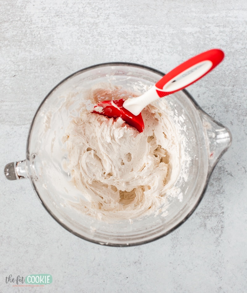 frosting in a glass bowl with a red spatula