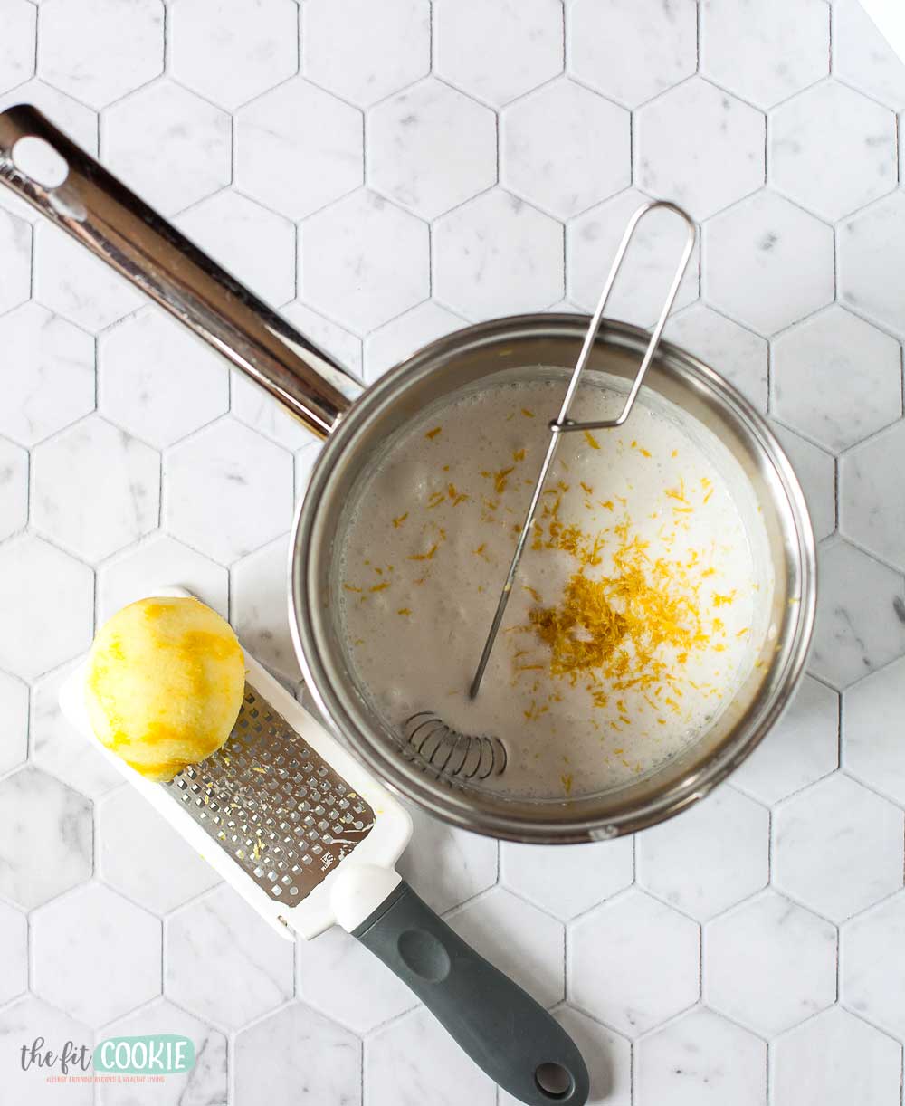 overhead photo of saucepan with coconut milk and lemon zest in it