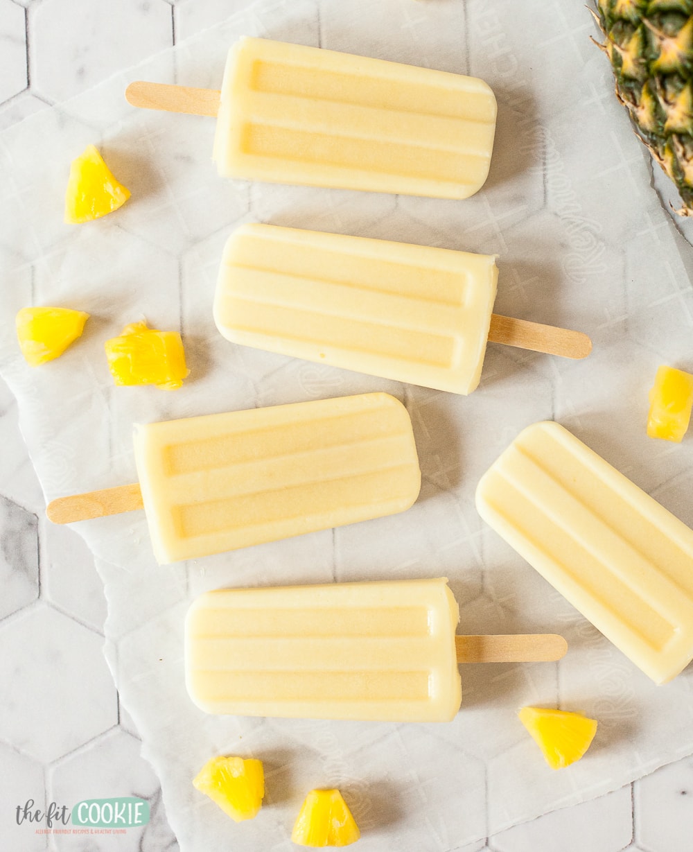 overhead photo of several popsicles and pieces of pineapple