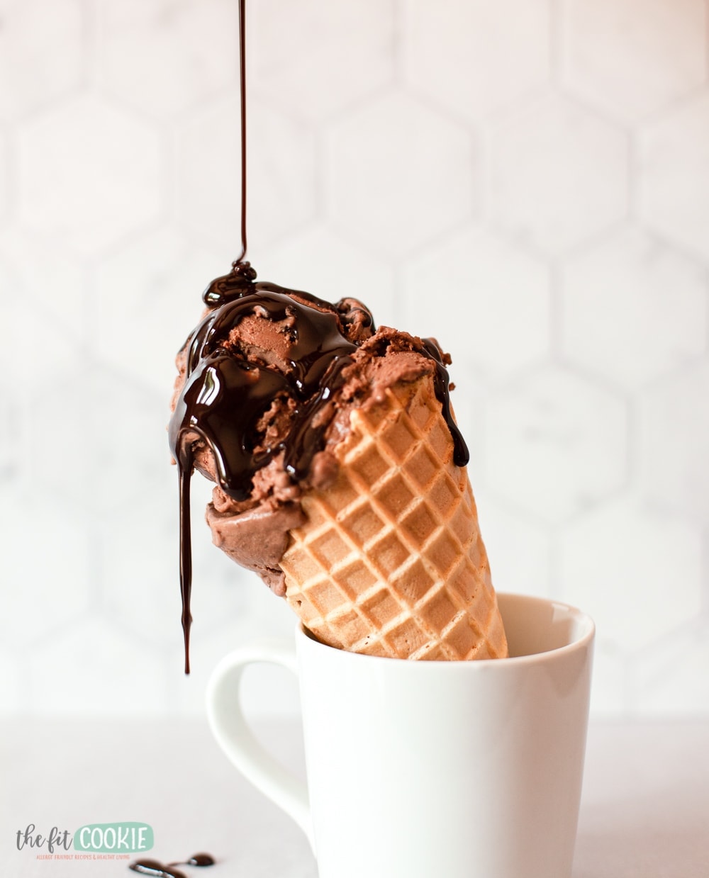 chocolate oreo ice cream on a waffle cone with chocolate sauce