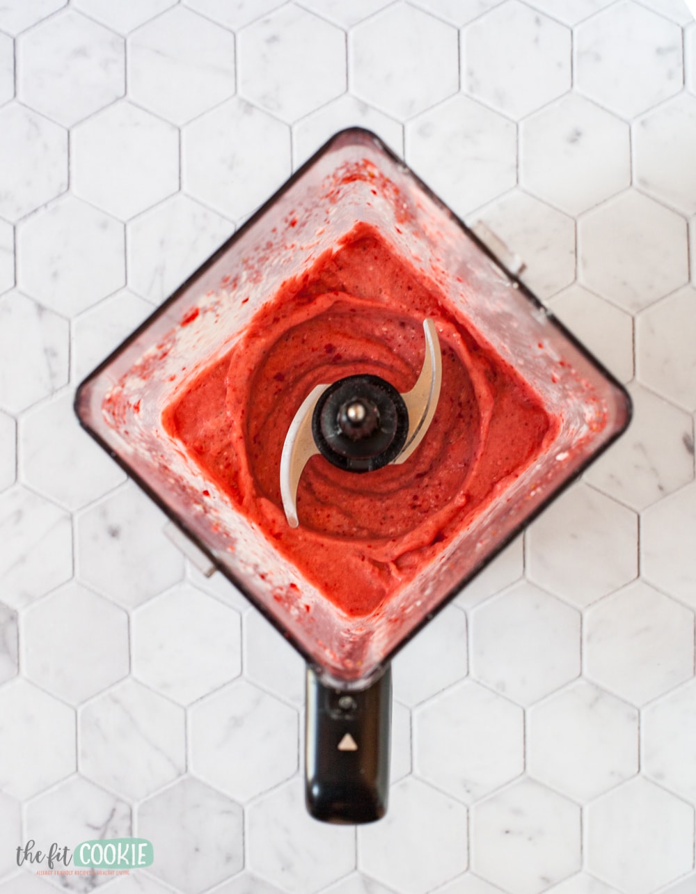 overhead photo of blender with frozen strawberries in it