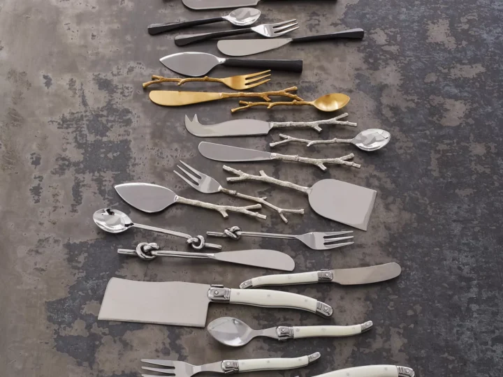 A lavish collection of silver and gold utensils, perfect as gifts for foodies, elegantly displayed on a table.