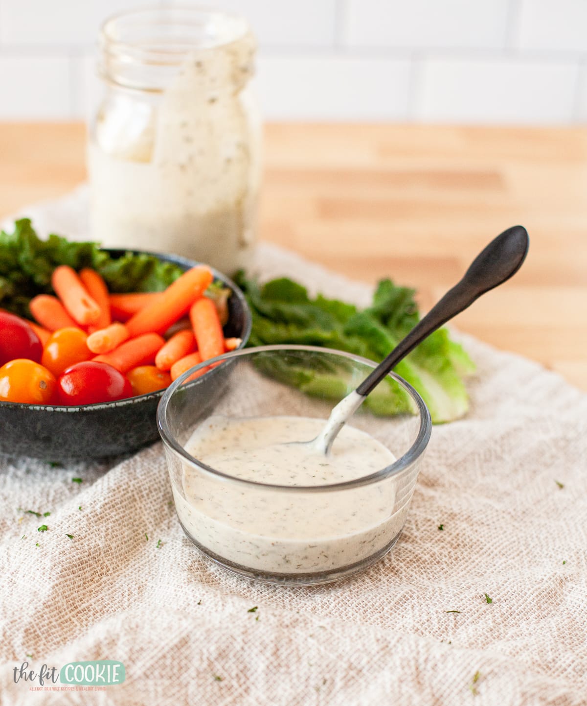 creamy dressing in a glass dish with a black spoon in it
