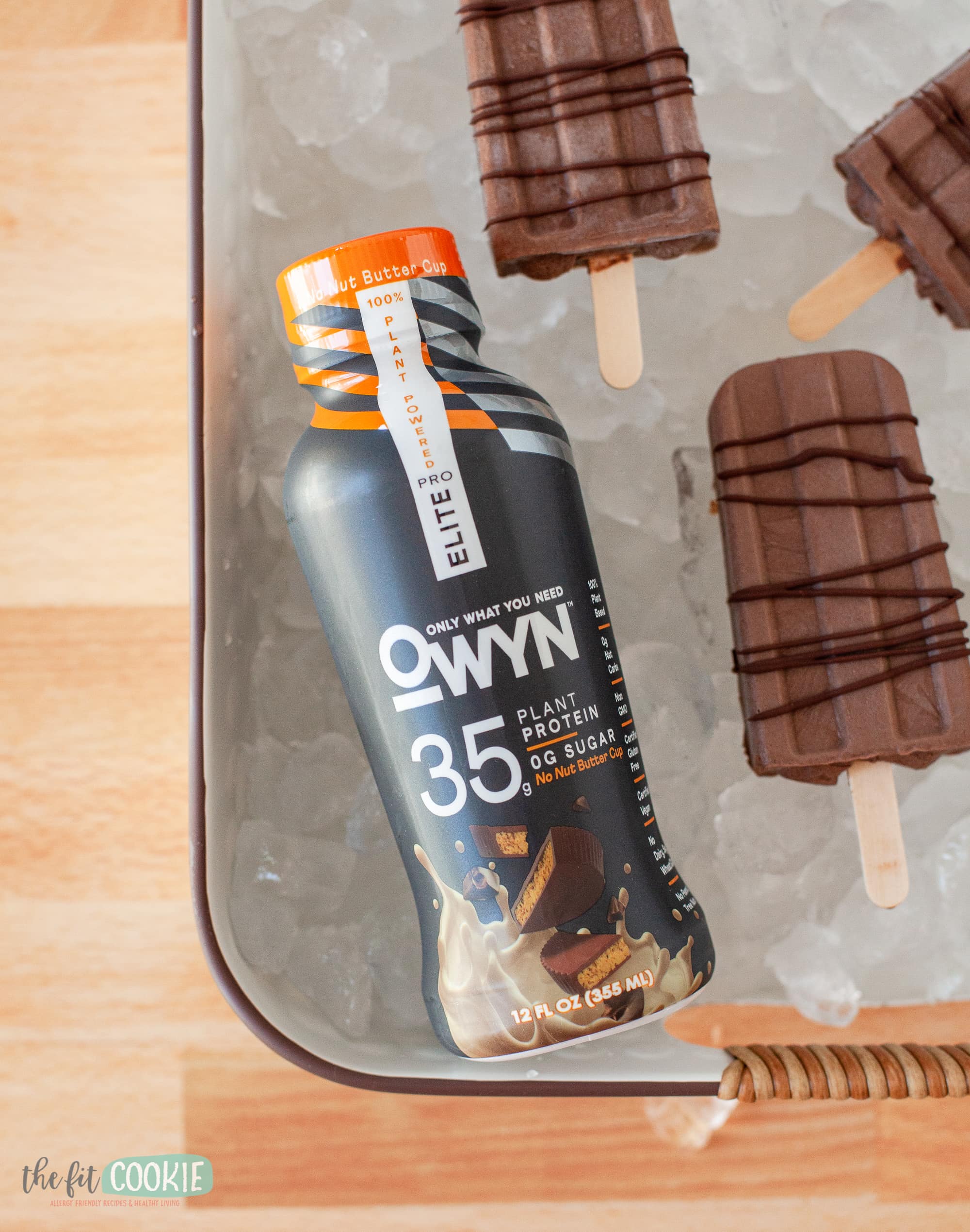 bottle of OWYN protein shake on ice with fudgesicles