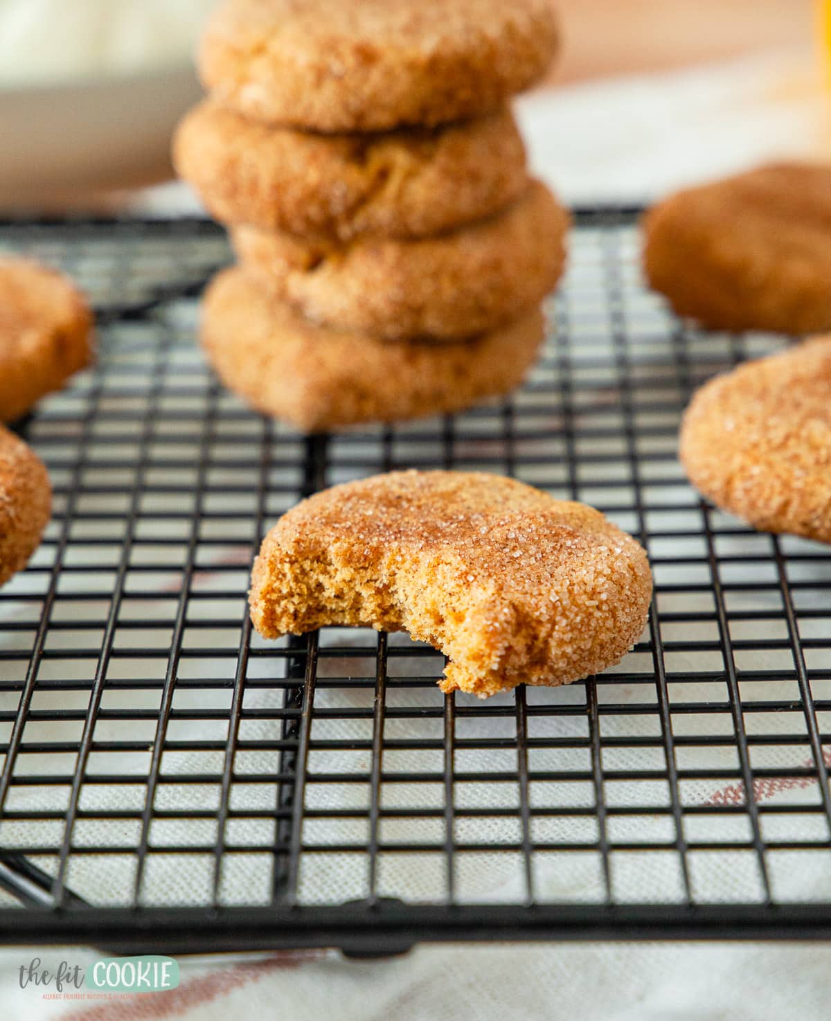pumpkin cookie on a cooling rack with a bite taken