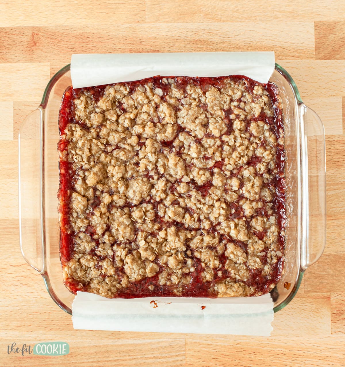 overhead photo of glass baking dish with uncut raspberry crumb bars in it