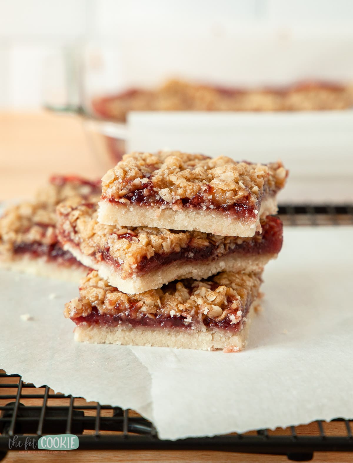 stack of allergy friendly raspberry crumb bars on parchment paper