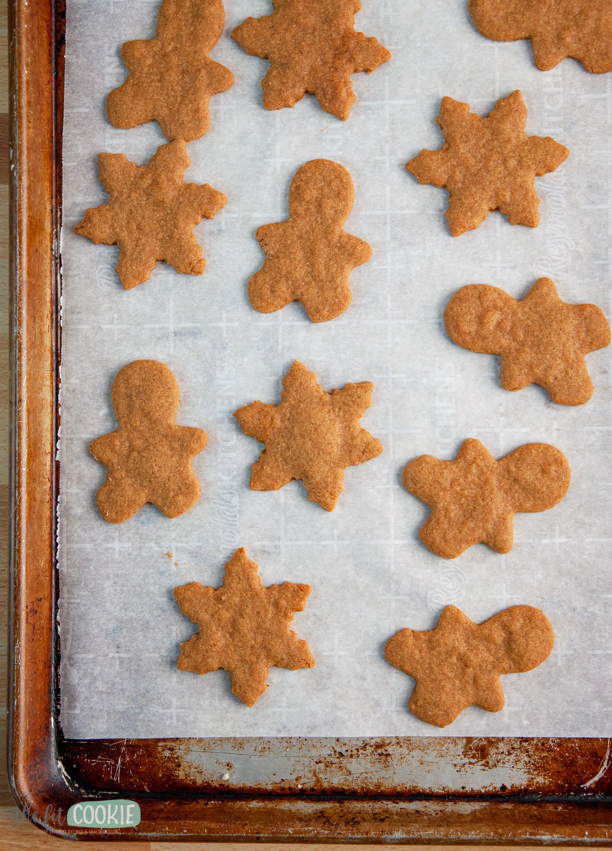 vegan gingerbread cookies on parchment paper on a cookie sheet pan