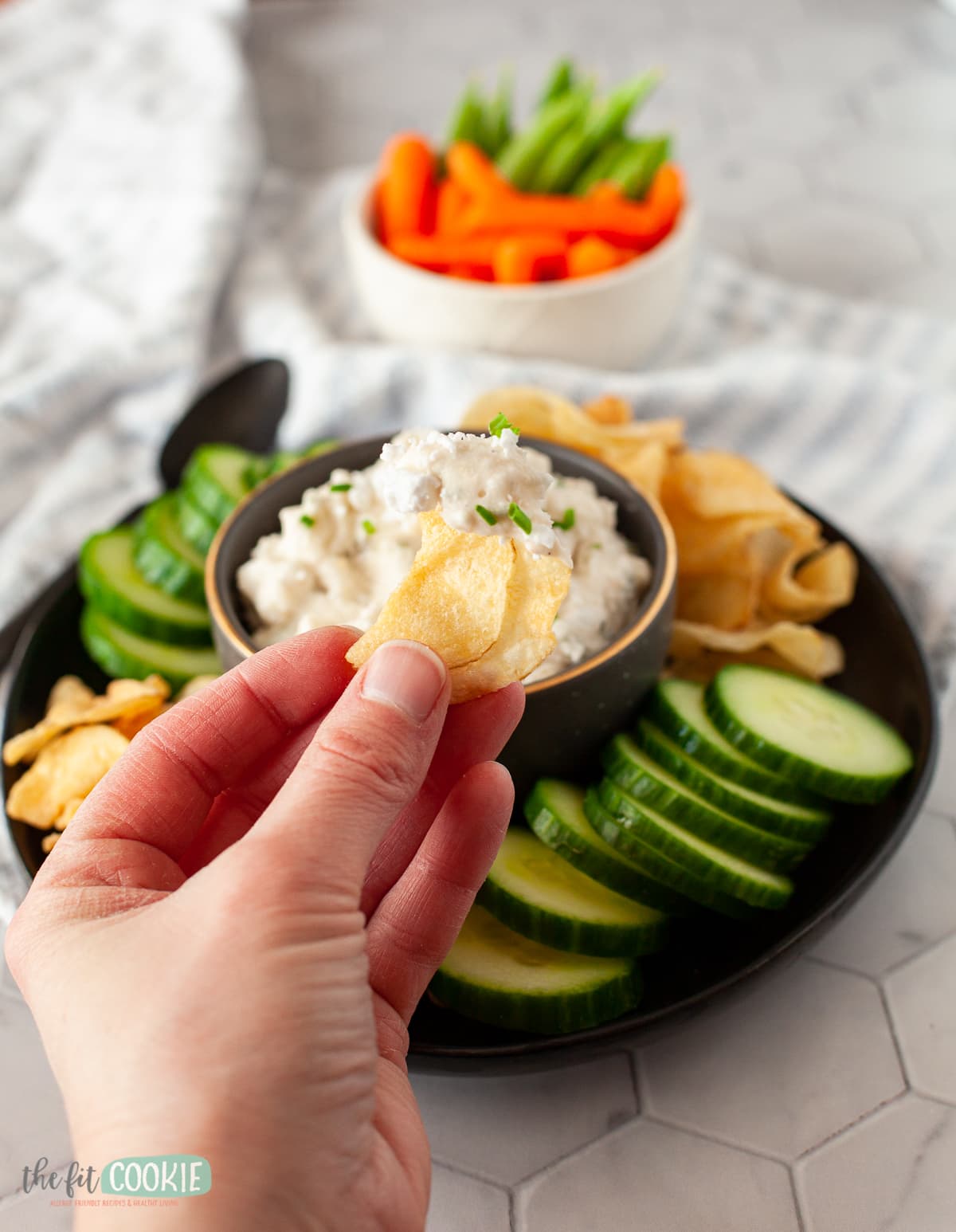 hand holding a chip with dairy free feta dip on it