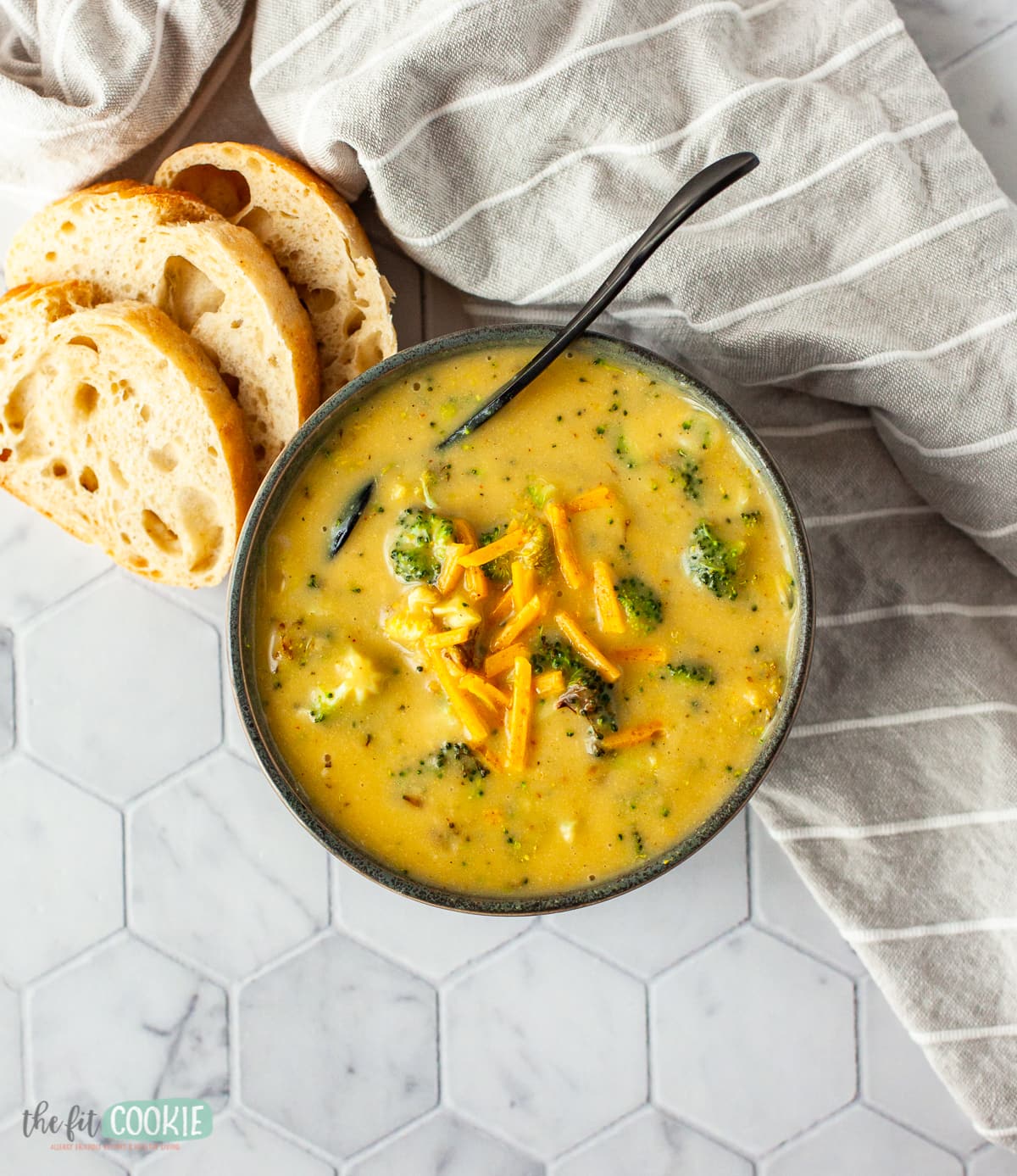 overhead photo of broccoli cheddar soup in a black bowl