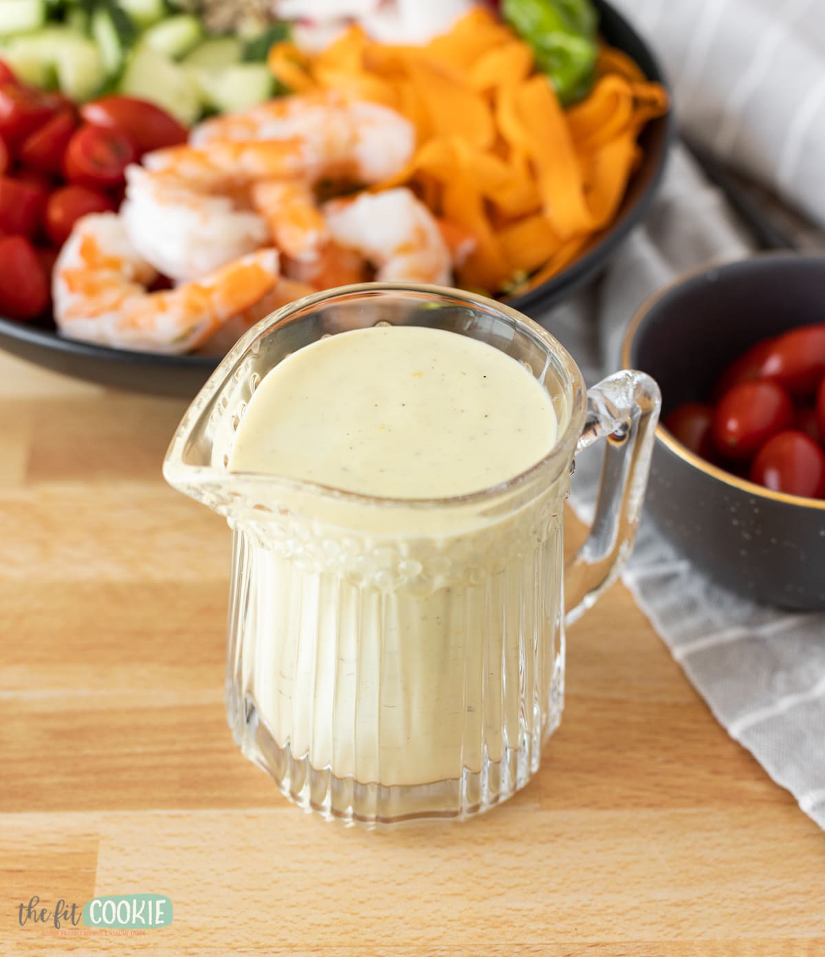 small glass pitcher filled with creamy lemon salad dressing. 