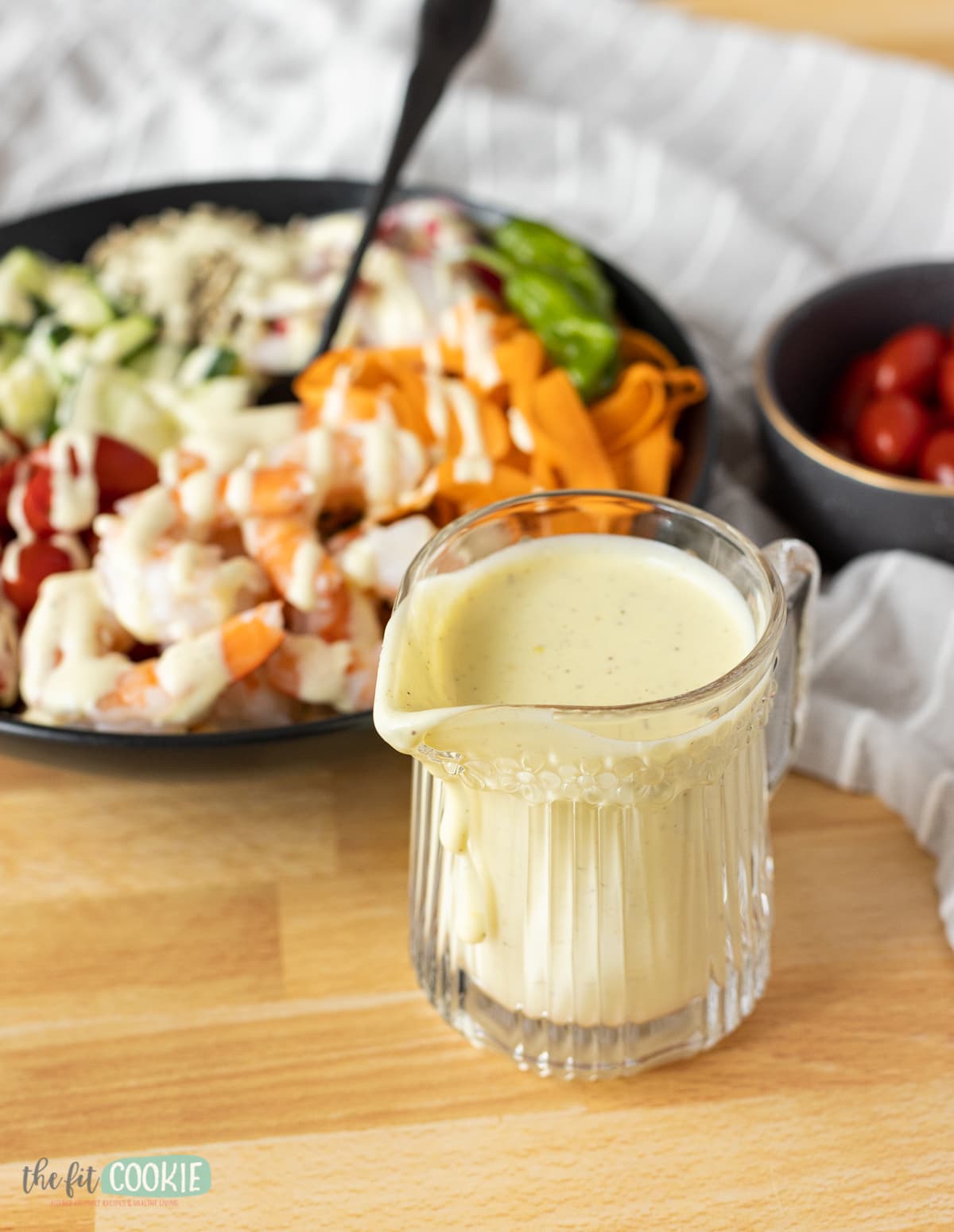 small glass pitcher filled with creamy salad dressing. 