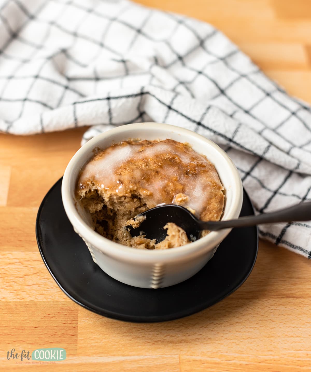 gluten free mug cake with a black spoon in it. 