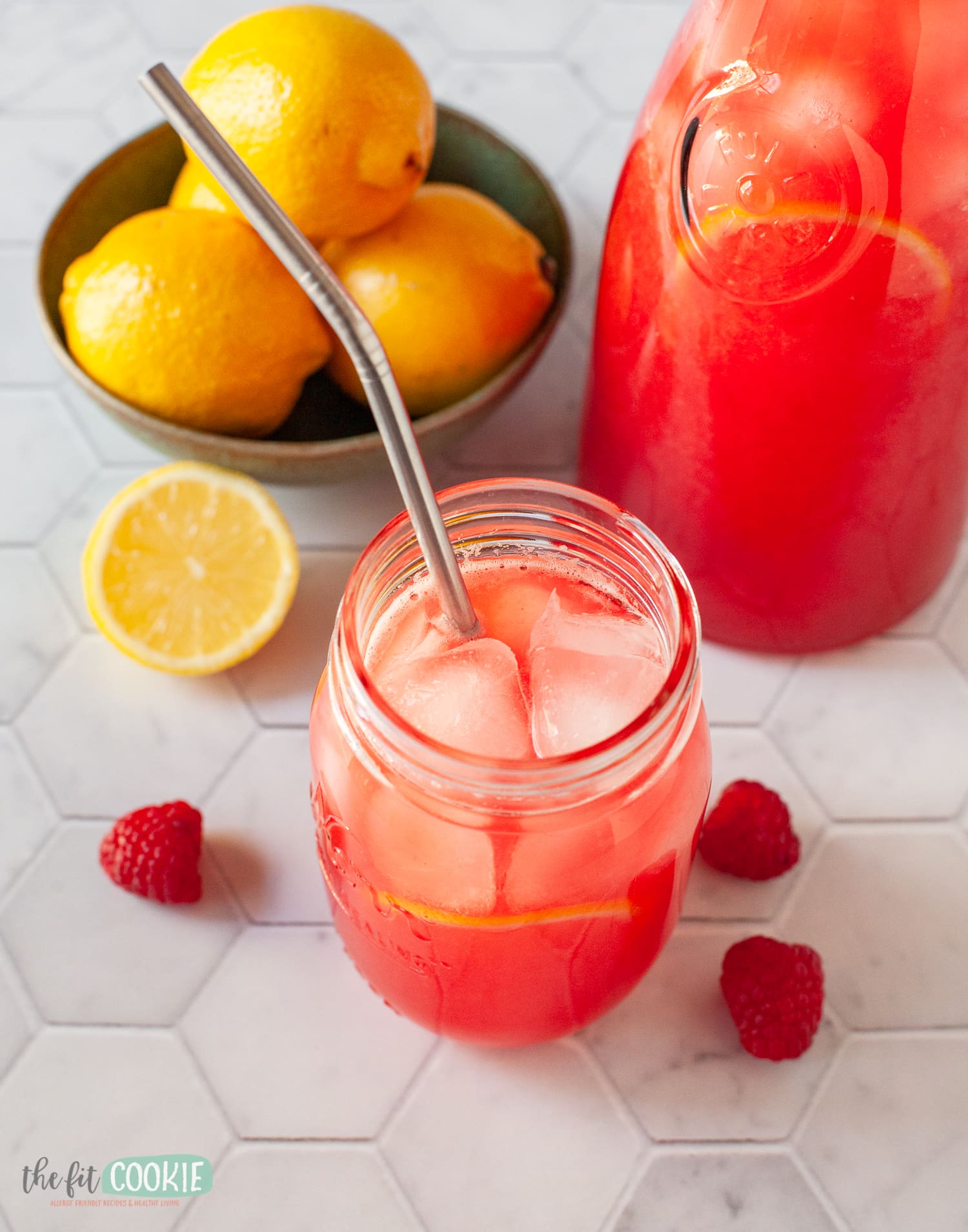 photo of pink lemonade in a glass jar with a metal straw. 