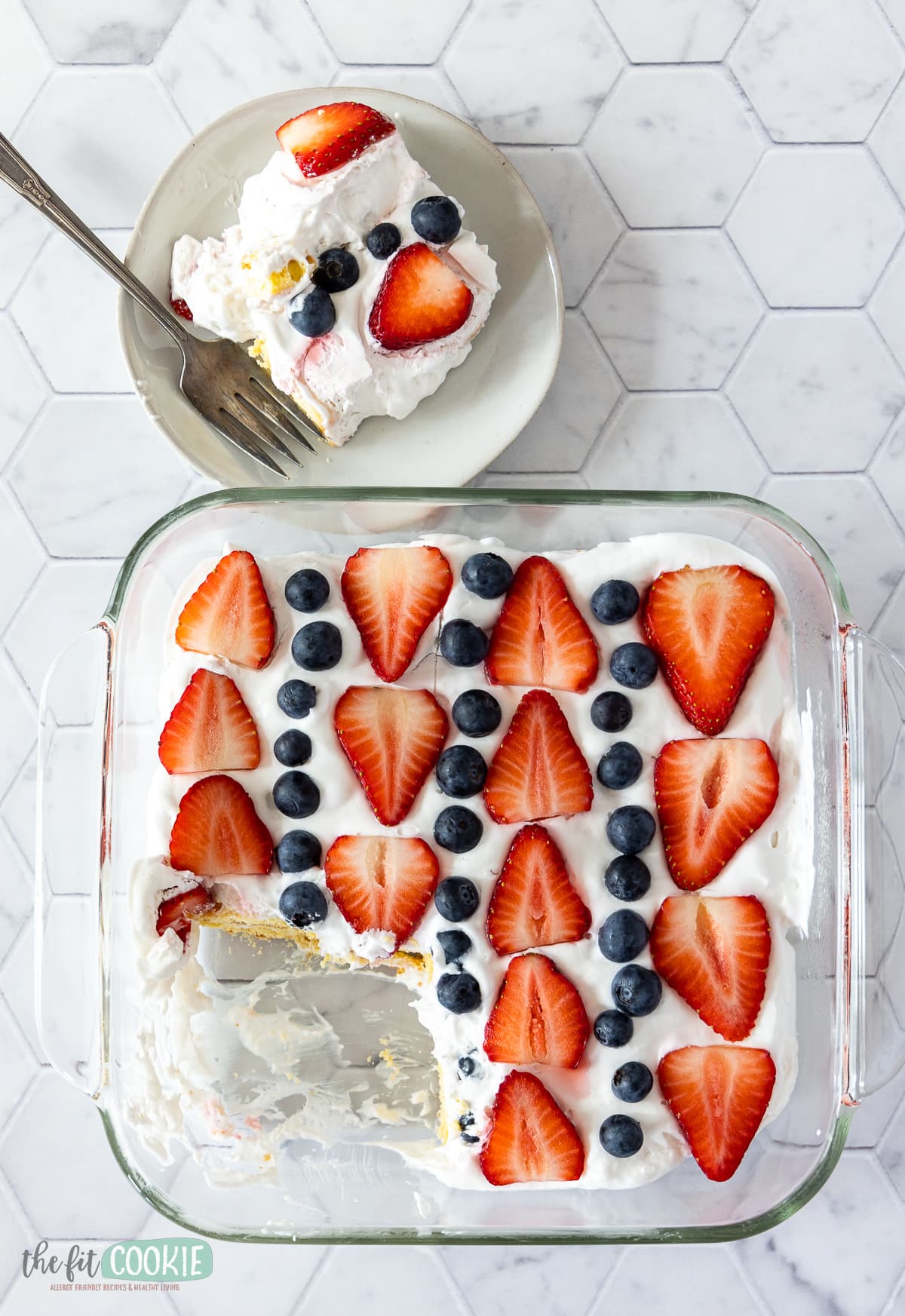 overhead photo of cake covered with strawberries and blueberries. 