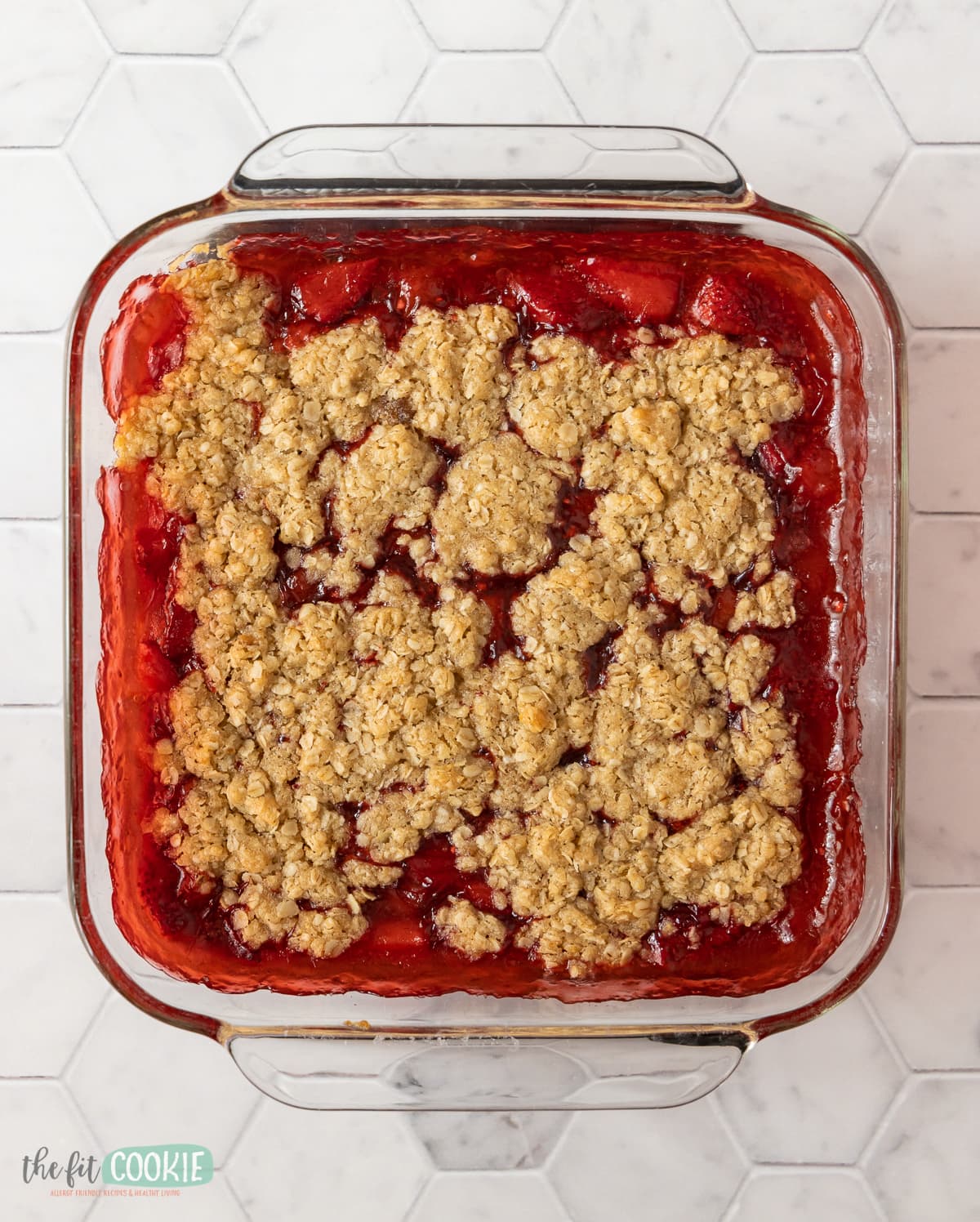 overhead photo of gluten free strawberry rhubarb crisp in a glass pan. 