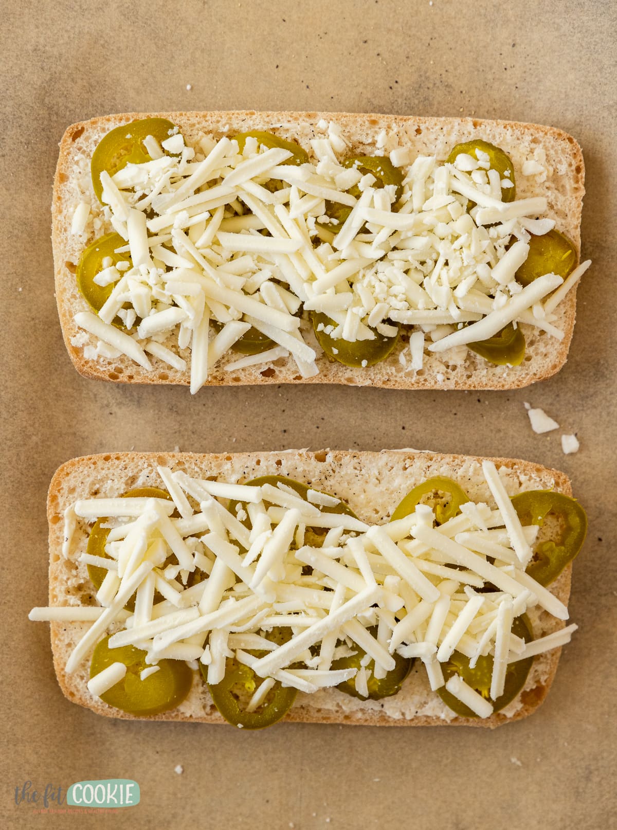 overhead photo of pieces of bread covered in jalapeno slices and unmelted dairy free cheese. 