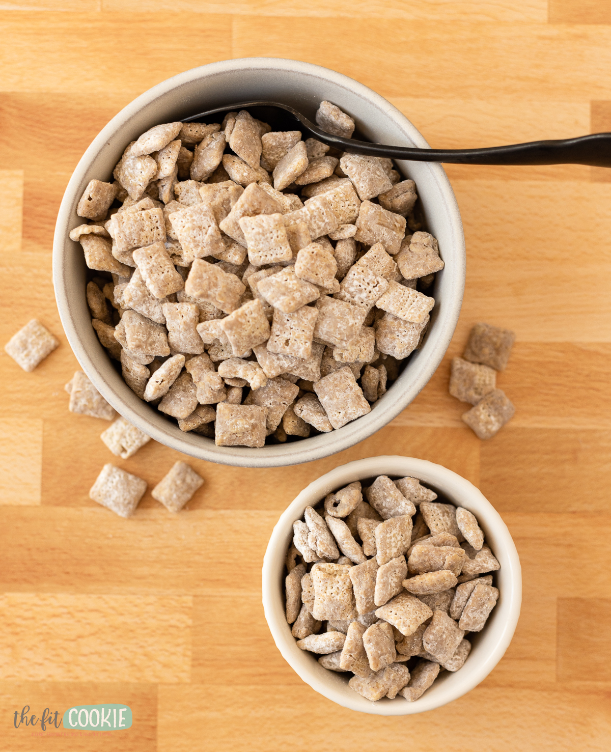 overhead photo of pumpkin spice puppy chow in white bowls with a black spoon. 