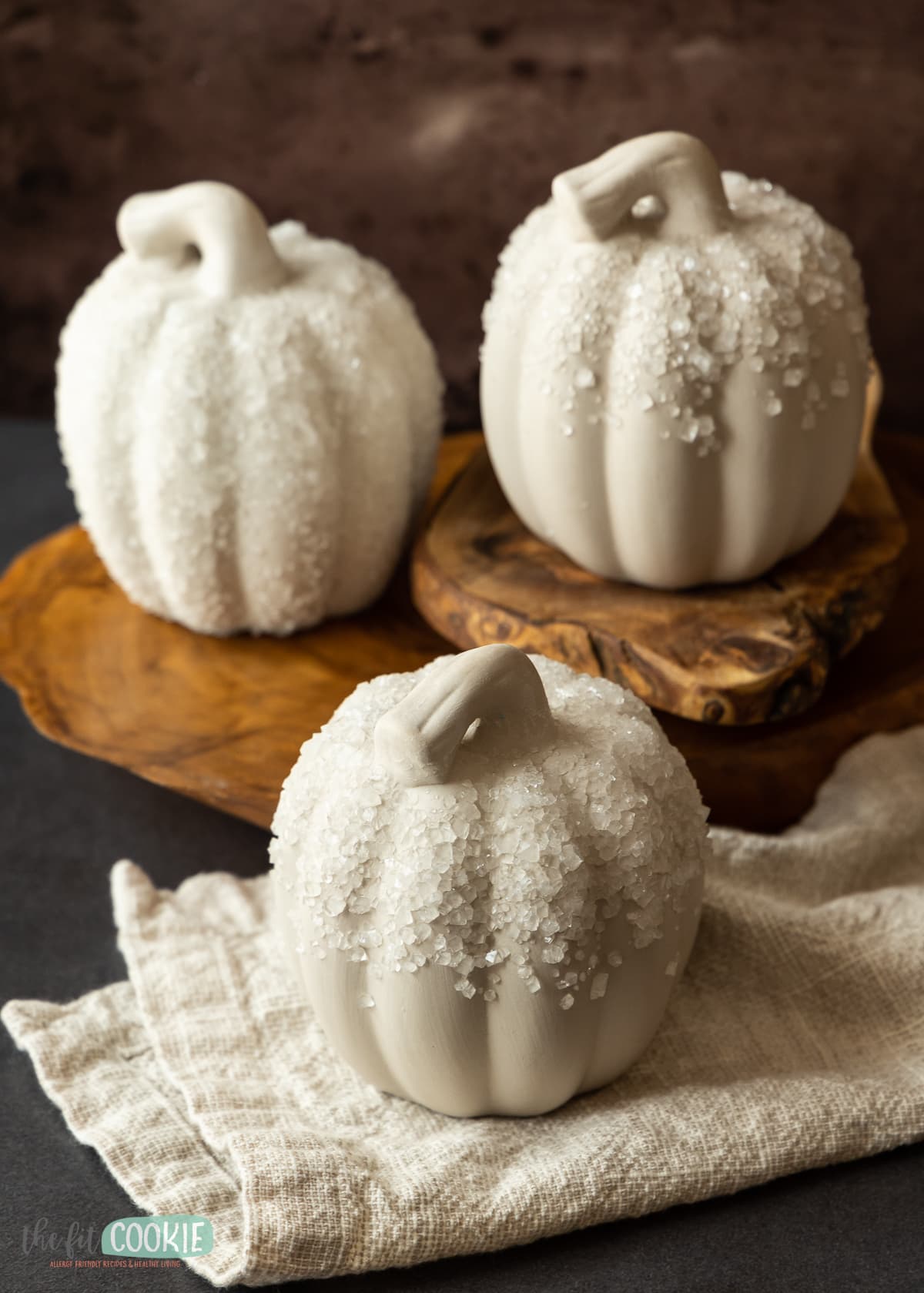 borax crystals on white pumpkins set on stacked pieces of wood. 
