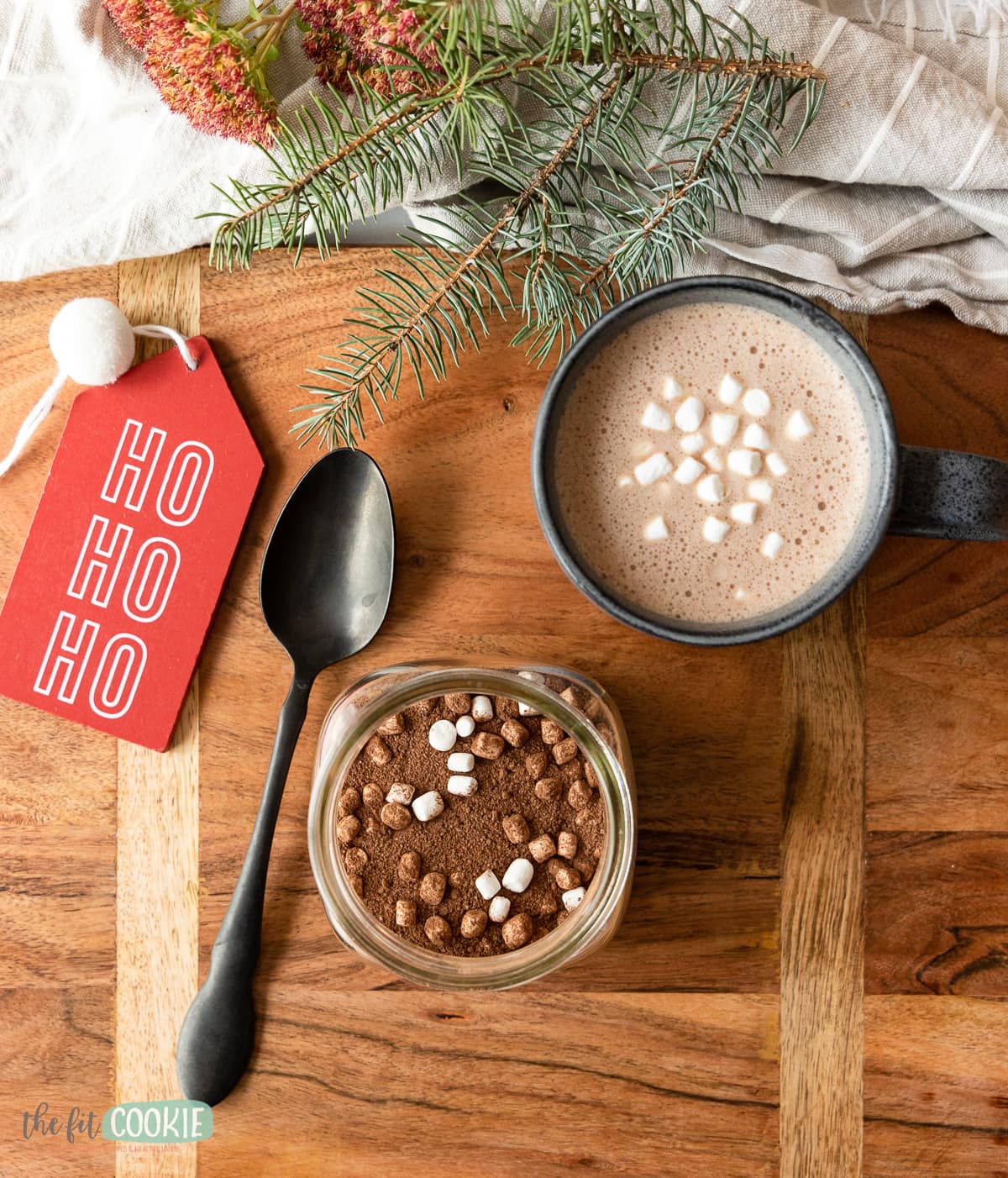 overhead photo of cup of hot cocoa on a wood cutting board. 