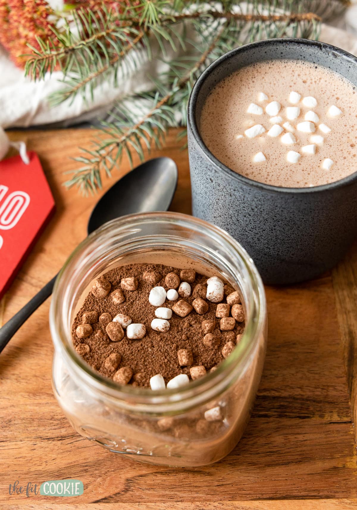 close up photo of dairy free hot chocolate mix in a jar next to a cup f hot cocoa. 