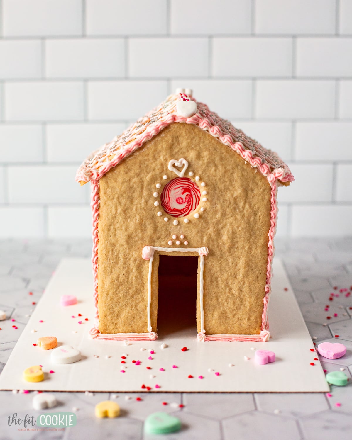view of the front of a valentine decorated gluten free sugar cookie house. 