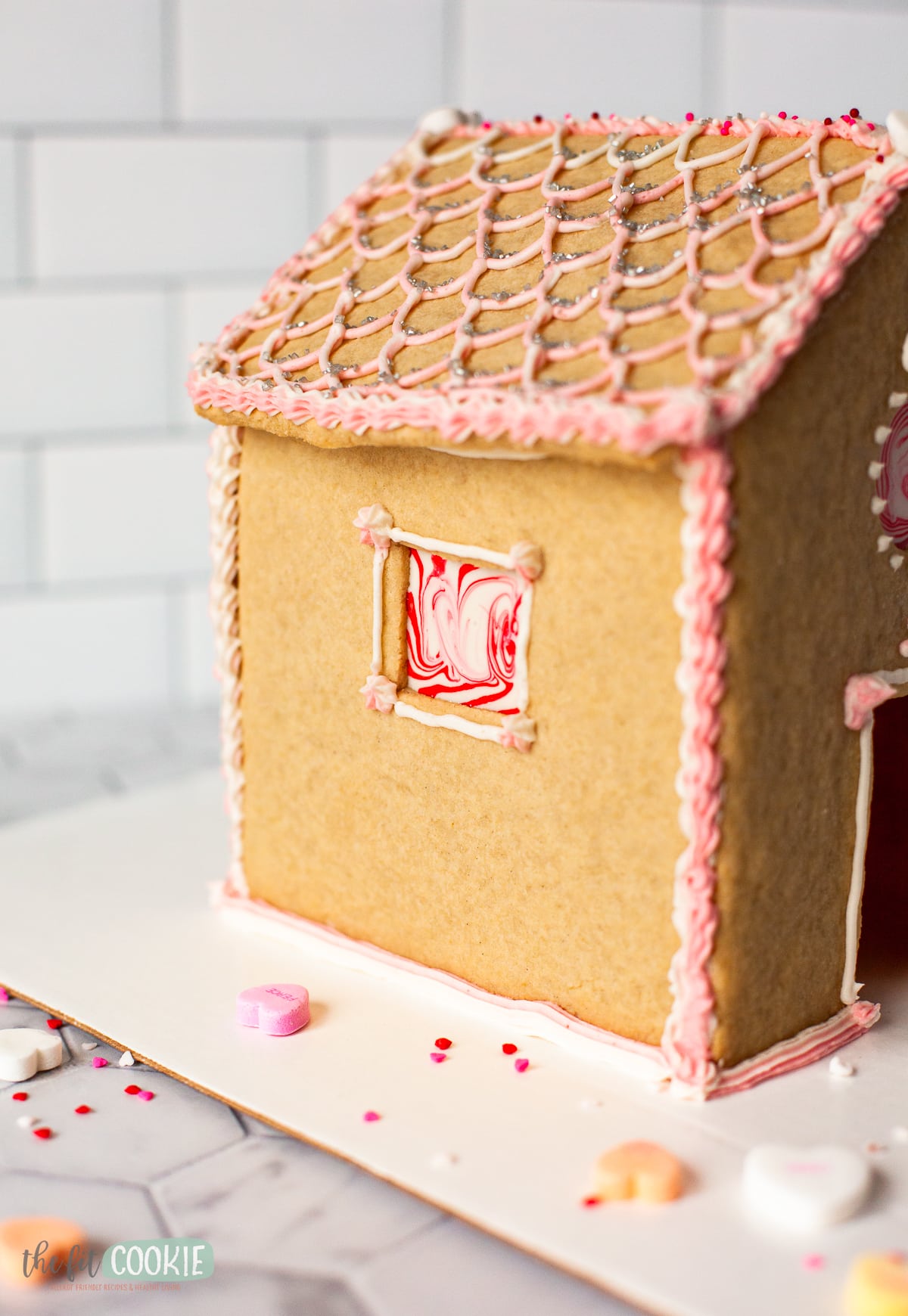 close up photo of a gluten free sugar cookie house with frosting and sugar decorations. 