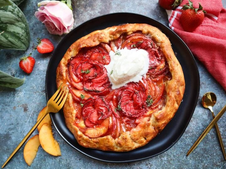 A tart with strawberries and whipped cream on a plate.