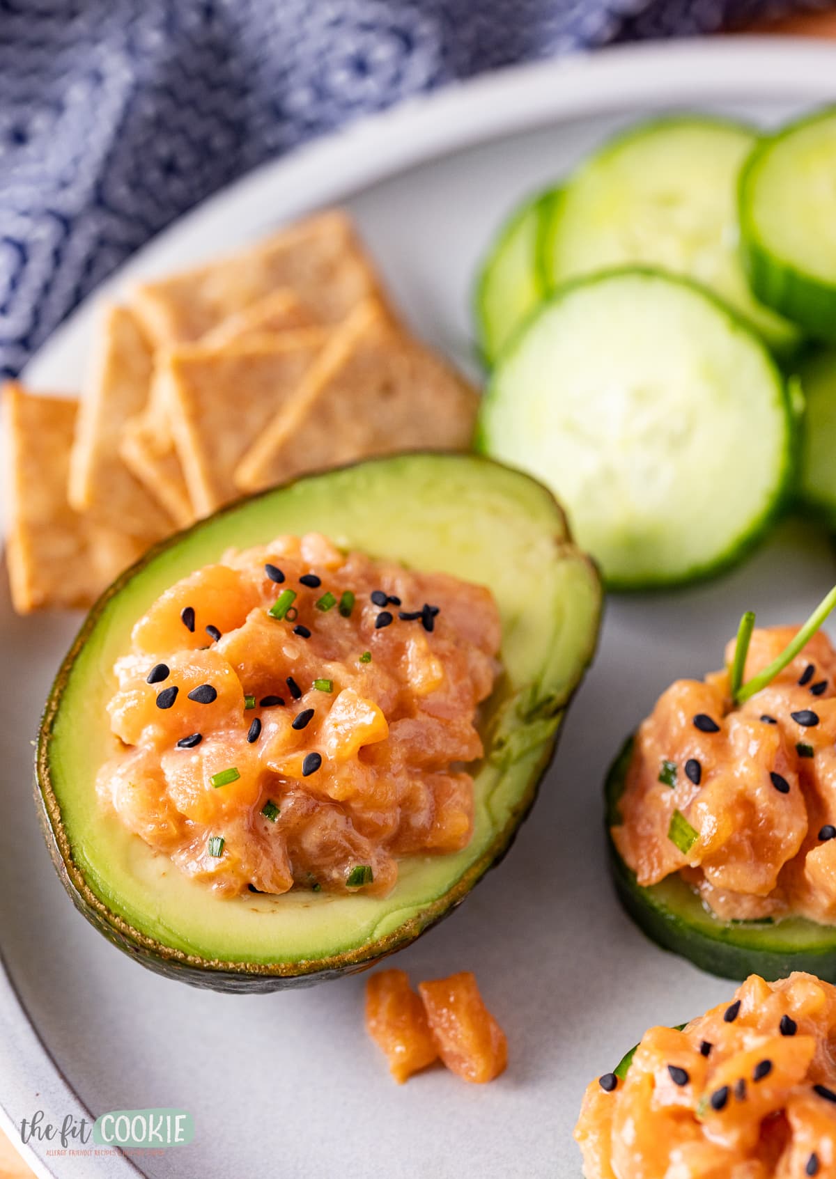 close up photo of salmon poke in an avocado half with black sesame seeds on top. 
